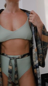 Close up of woman wearing luxury kimono robe over  swimsuit.
