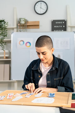 Caucasian young woman working as fashion designer in tailor studio. 