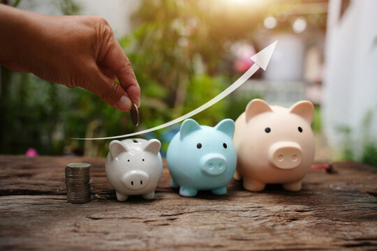 Hand Putting Coin into Piggy Bank with Rising Arrow for Savings and Financial Growth