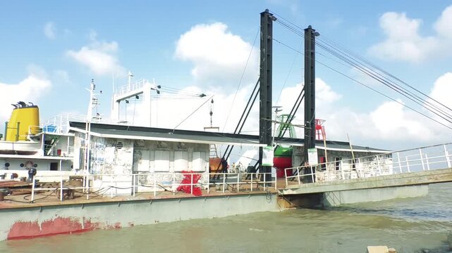 Industrial river gate sluice structure with tall black posts and metal crane mechanism