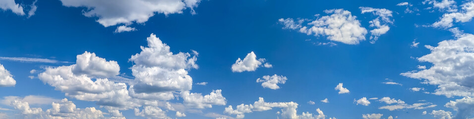 Fototapeta premium Banner of cumulus clouds massive and empty space for your text. A stream of clouds slowly follows the sky. Windy weather of a beautiful day. Cover with copy space for a website or mobile application.