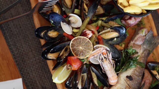 Fresh seafood platter combines mussels clams shrimp grilled fish vegetables and lemon creating a colorful restaurant meal inspired by coastal cuisine and summer dining traditions