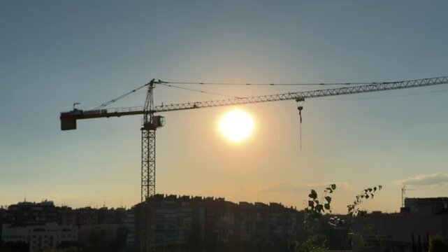 Construction crane silhouette against the sunset sky
