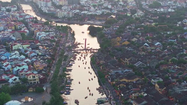 Aerial sunset view of Hoi An Ancient Town and Thu Bon River with boats, Vietnam