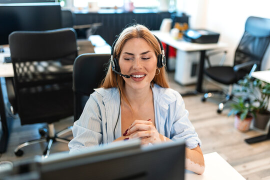 Customer service support representative. Call center operator working at computer desk, Smiling woman wearing headset. Professional hotline agent talking with client.