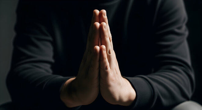 Hands in Prayer Position Against Black Background for Meditation and Spiritual Reflection