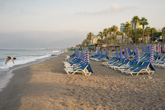 Sand Beach with Sun Loungers and Pier on sea in Alanya, Turkey