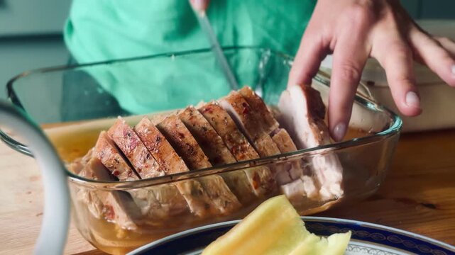 An adult woman's hands slicing oven-cooked meat. Concept: preparing healthy food, meat, chicken, chicken breast.