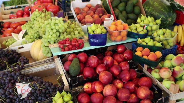 Colorful farmers market offers fresh grapes figs peaches strawberries apples avocados and melons showcasing abundant seasonal produce and healthy Mediterranean summer food