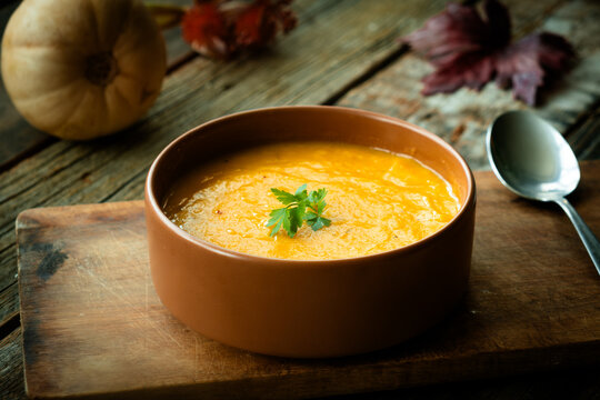 Bowl of pumpkin soup. Tradition autumn food, vegetable cream soup. Thanksgiving dinner in rustic style