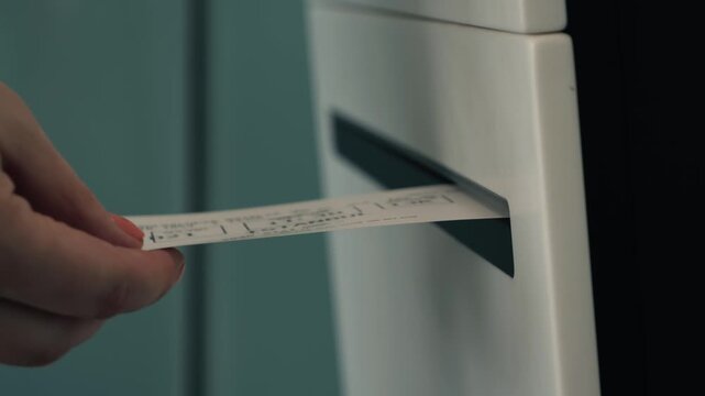 Close-up of a passenger printing a boarding pass at a self-service check-in kiosk in an airport. Modern automated travel technology for fast airline check-in before departure. High quality 4k footage