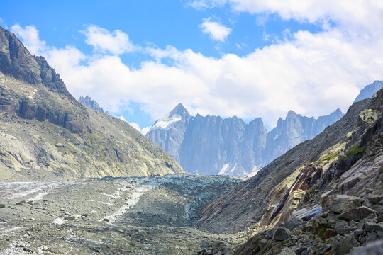 panoramic view of alpine glacier valley and rocky mountain peaks under blue sky, French Alps and majestic glacier