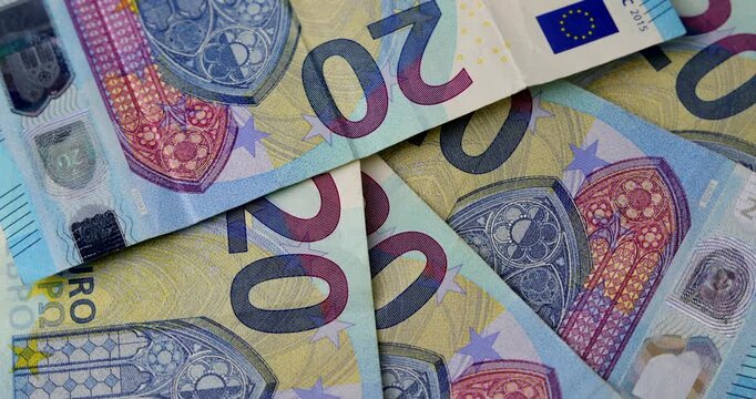 A top view of several twenty euro paper banknotes scattered randomly and spinning slowly showing business wealth, investment and currency exchange concept.
