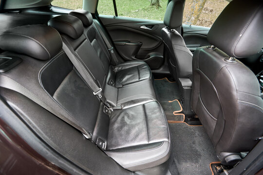 Berlin, Germany - April, 8 2026: Interior of brown Opel Astra K Sports Tourer wagon 5th generation with black leather seats, headrests, safety belts, steering wheel fragment and custom floor mats.