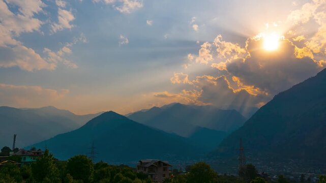 4K Time-lapse shot of sunrays in front of Himalayan mountain peak during the sunset at Manali in Himachal Pradesh, India. Sun beams moving during the sunset. God rays shining through clouds