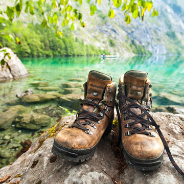 Hiking Boots Resting by a Crystal Clear Mountain Lake in Summer
