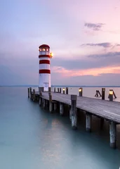 beauty red and white striped lighthouse in sunset light at the calm sea © Jenny Sturm