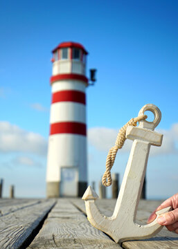 hand holding a wooden anchor on the jetty at the lighthouse