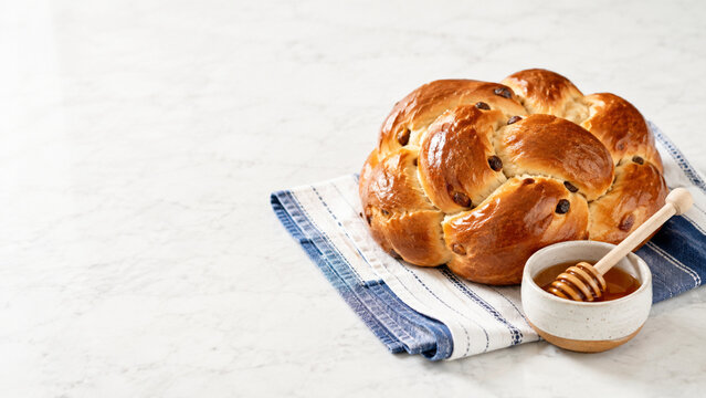 Round braided challah bread with honey dish for Jewish New Year