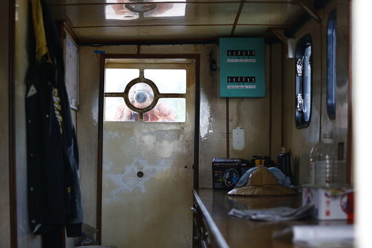 A Photographer Appears Through an Old Boat Door.