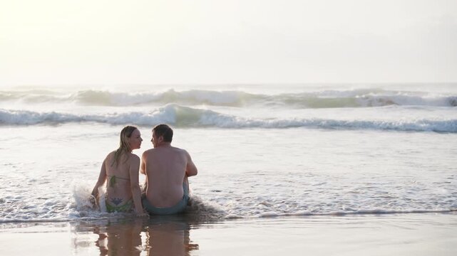 Happy couple relaxing together by the ocean, sharing quiet moments and enjoying quality time during a beach vacation. Wellness, travel and healthy relationships concept.