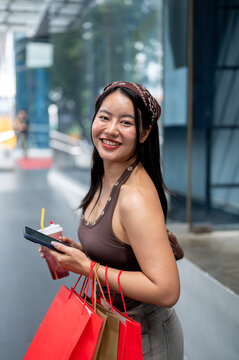 Side View Portrait of Smiling Asian Woman with Shopping Bags