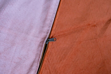 Close-up of a zipper being stitched onto corduroy fabric for a custom pillow cover © renipurnama