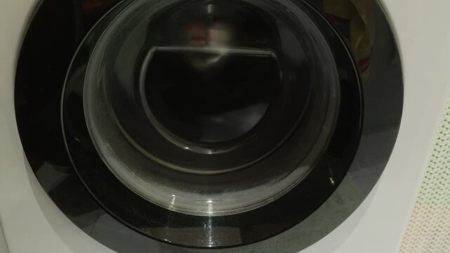 Close up view of washing machine drum rotating during spin cycle, capturing mechanical motion, texture details with authentic sound effects.