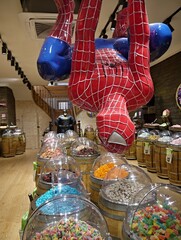 Fototapeta premium Spider-Man statue hanging over candy store barrels