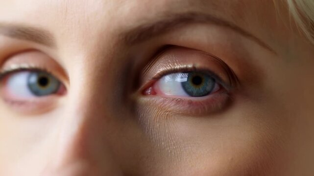 Extreme close view of eyes with slow eyelid movement, subtle gaze shift, soft diffuse light, blue green iris reveal, natural skin texture, calm intimate expression