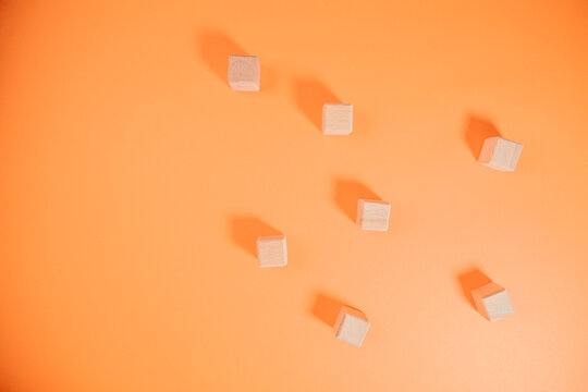 Wooden cubes on orange background. Top view. Copy space.