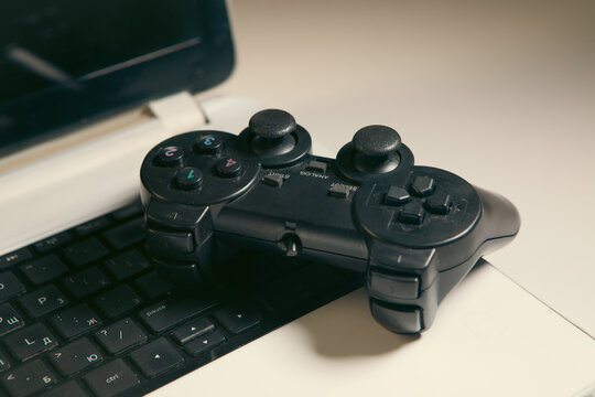 Gamepad and laptop on the table. Selective focus. Toned.