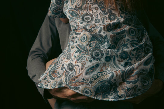 Couple in love embracing and kissing on black background, closeup