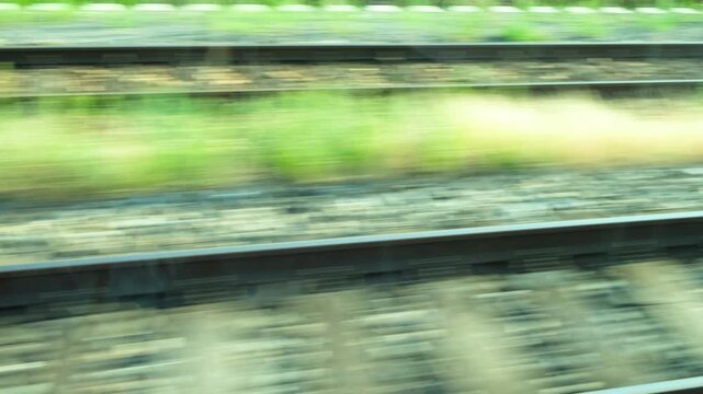 Railway tracks blurs passing by from fast moving train window