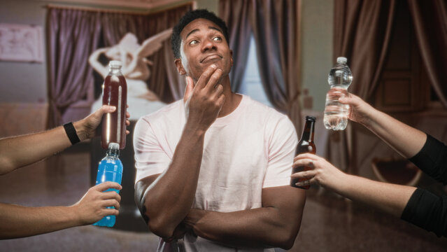 Man biting fingernail with arms crossed while multiple hands offer bottles in studio; peer pressure uncertainty.