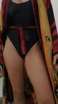 Close up of woman wearing luxury kimono robe over  swimsuit.