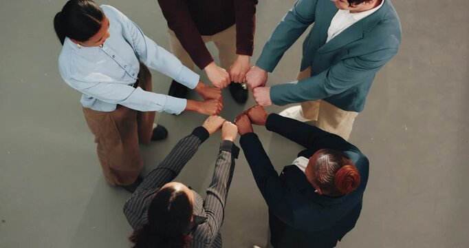 Above, business team and fist bump for solidarity with huddle, trust and support with motivation. Circle, hands together and people in office with community, collaboration and corporate goals