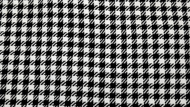 Classic houndstooth fabric pattern featuring high contrast black and white woven threads with intricate textures