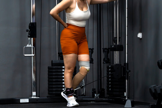 Woman with prosthetic leg training in gym, demonstrating effort and self-improvement
