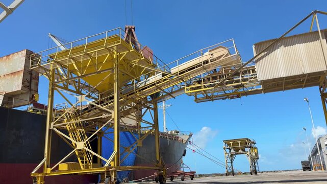 crane grab discharge grain to hopper with conveyor belt.