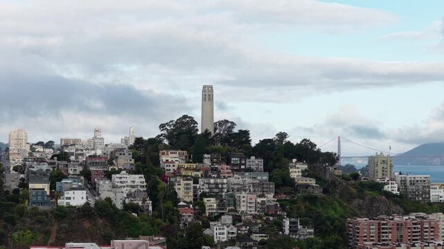 Coit Tower On Telegraph Hill On Dramatic Morning In San Francisco, California. Golden Gate Bridge In Background. Drone sideways shot