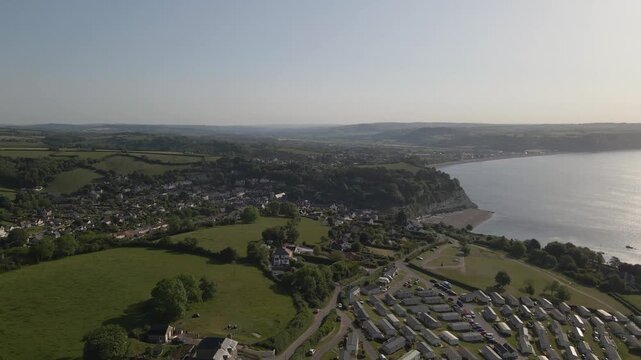 Aerial shot of Seaton Holiday Caravan Park, Devon, capturing holiday homes, green spaces, and the scenic landscape surrounding the seaside town. This highlights coastal tourism, leisure accommodation.