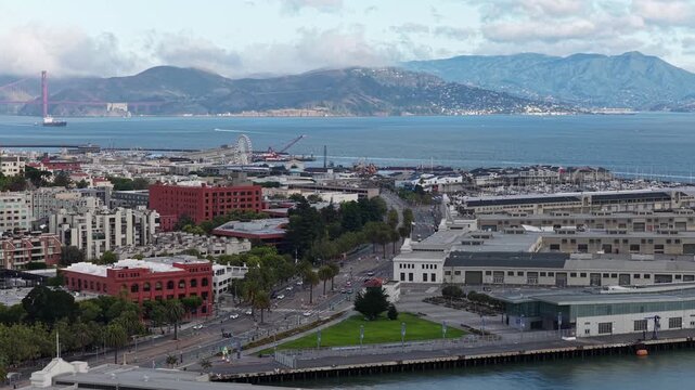 Morning View Of Embarcadero Waterfront With Golden Gate Bridge In Distance In San Francisco, California. aerial sideways shot
