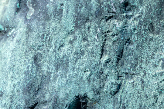 Weathered bronze patina texture close-up of oxidized copper surface with green teal corrosion