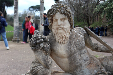 Naklejka premium Statua barbuta di una divinità fluviale o Oceano in posa semisdraiata nell'area del Canopo a Villa Adriana, Tivoli, Italia