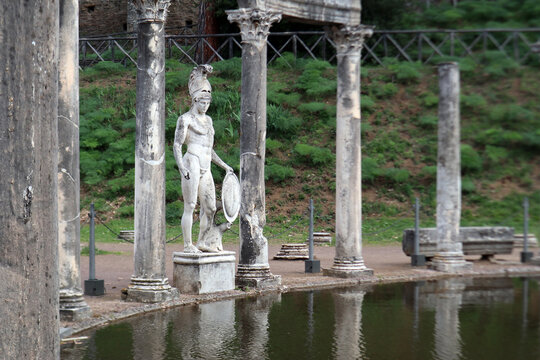 Statua classica del dio Ares tra le antiche colonne corinzie del Canopo a Villa Adriana riflesse sulla superficie della vasca, Tivoli, Italia