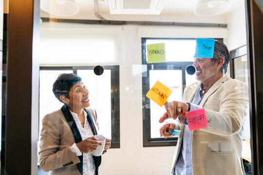 Diverse business people collaborating on strategy, discussing business development and solutions in modern coworking office space
