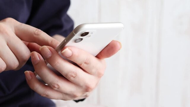 スマートフォンを操作する手元