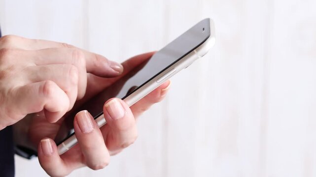 スマートフォンを操作する手元