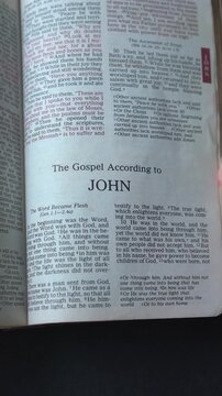 Opening to the book of John of the New Testament in the Holy Bible. New Revised Standard Version. Vertical video.
